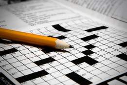 pencil resting on crossword puzzle