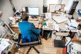 worker at cluttered desk photo