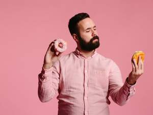 man undecided about which donut to eat