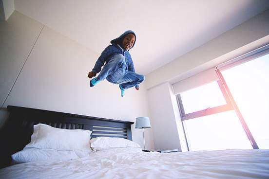 child jumping on bed