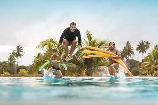 family jumping into pool