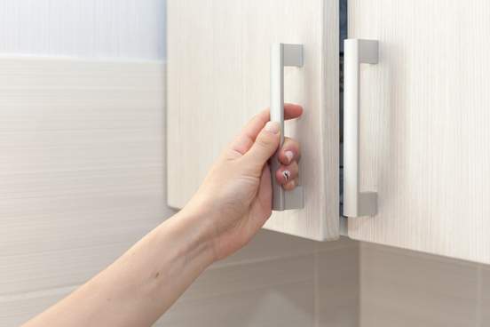 hand opening cupboard