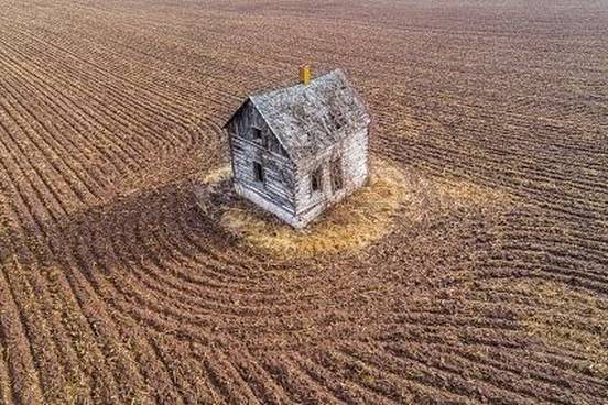 house-in-middle-of-plowed-field