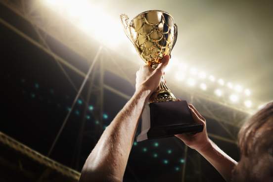 man holding up trophy