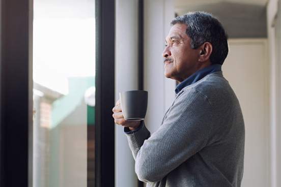 man looking out window