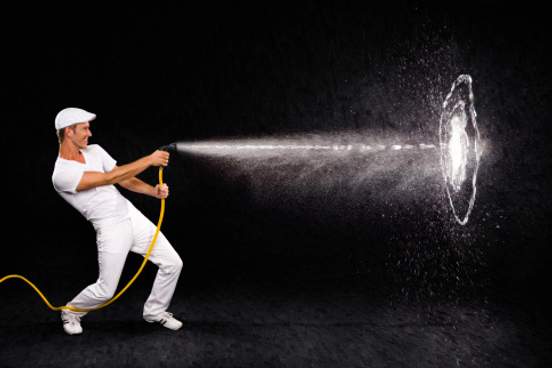 man spraying hose