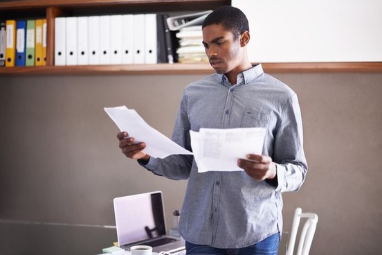 man comparing papers