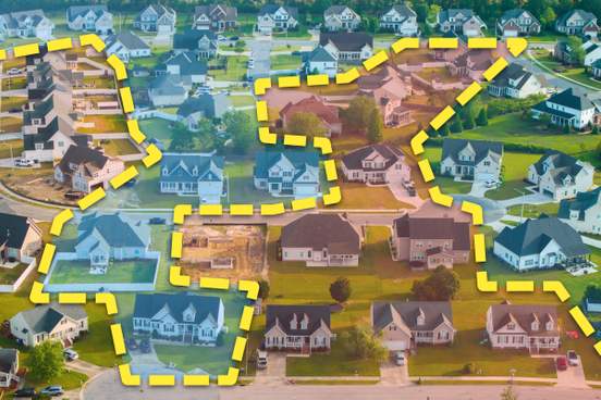 photo illustration of a suburban neighborhood divided by a dotted yellow line that meanders between properties in an irregular shape blue and red color overlays are applied to eac