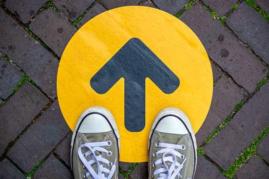 sneakers standing on yellow arrow