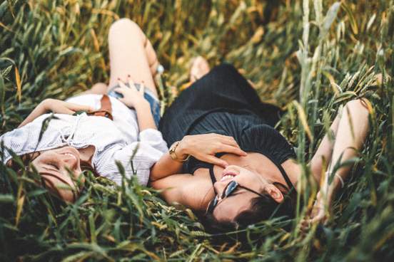 two friends lay in the tall grass talking