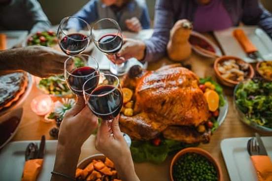 wine glasses toasting over thanksgiving dinner