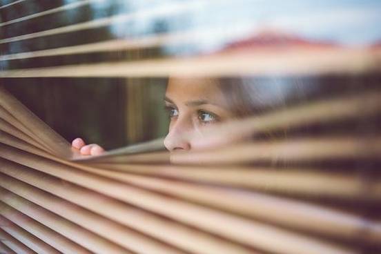 woman-looking-through-blinds