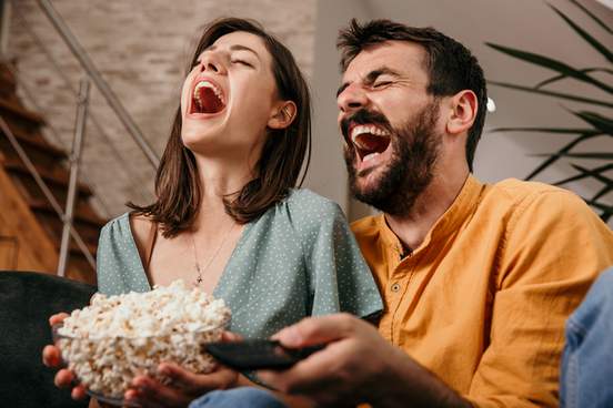 Merriam-Webster Words of the Week Young%20couple%20sitting%20on%20couch%20eating%20popcorn%20and%20laughing%20loudly-10338-b211fa8b5ec25a941ffb06c9814fa4dc@1x