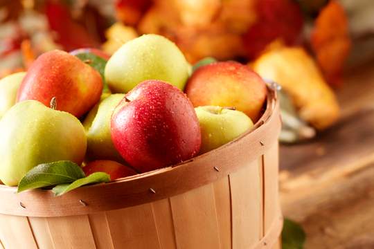 a wooden basket with apples in it