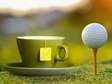 a cup of tea and a golf ball on tee side by side 
