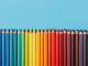 a row of colored pencils on a blue background